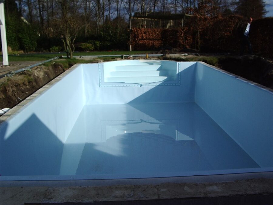 Bassin met lichtblauwe folie en brede traptreden aan het uiteinde, omgeven door tuin en bomen.