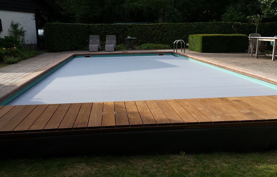 Lichtgrijze lamellenafdekking met brede houten vlonder langs het bassin, tuinset op het terras in Leusden.