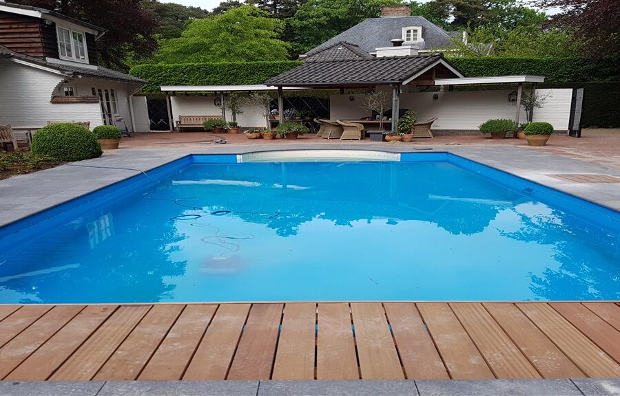 Gerenoveerd zwembad met blauwe folie en houten vlonder voor het woonhuis in Bilthoven.