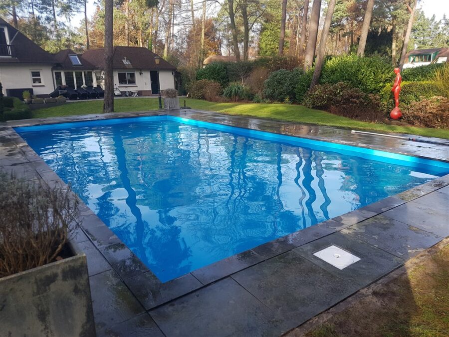 Gerenoveerd buitenbad met blauwe folie in een bosrijke tuin in Soest, op de achtergrond het woonhuis.