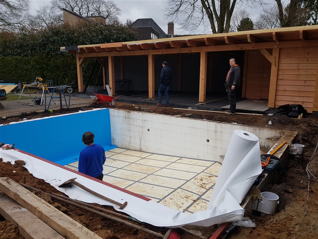 Blauwe folie op de wanden, de vloer wordt nog bekleed, met een rol vlies ernaast.