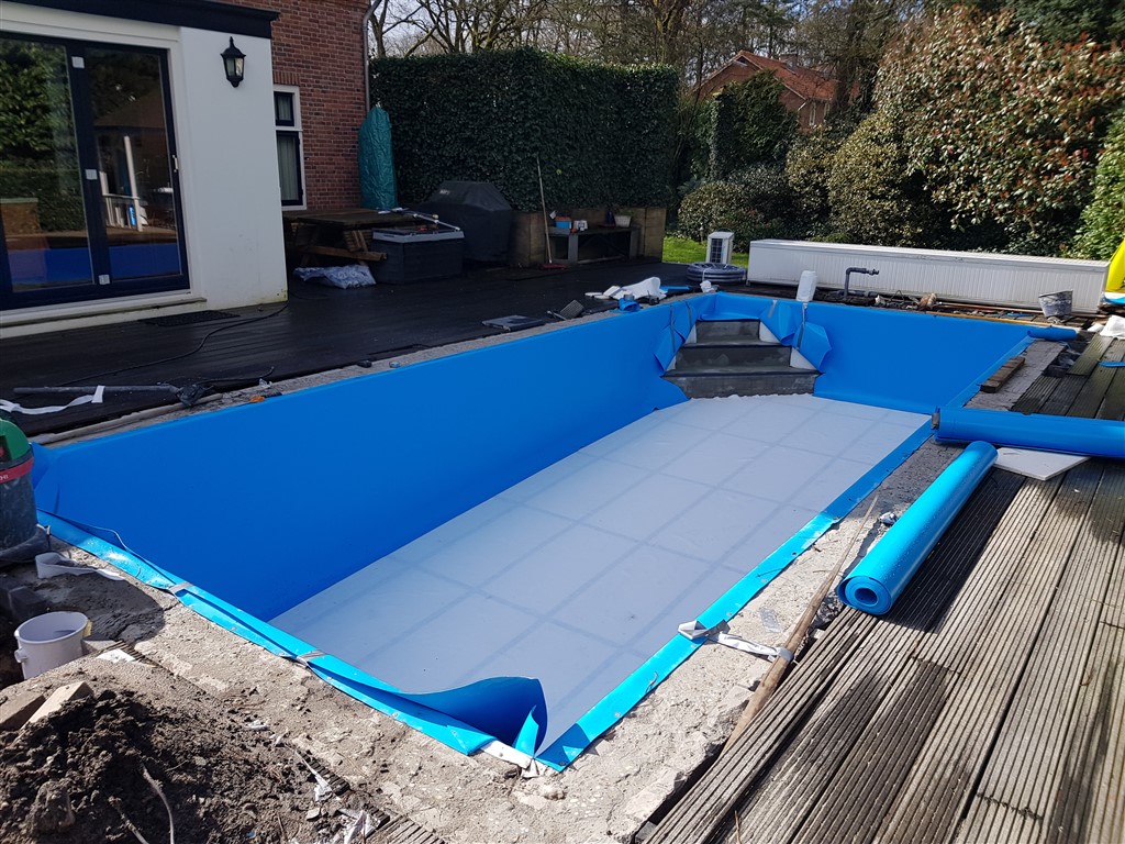 Blauwe folie op wanden en trap, met een lichte vloer en een rol folie.